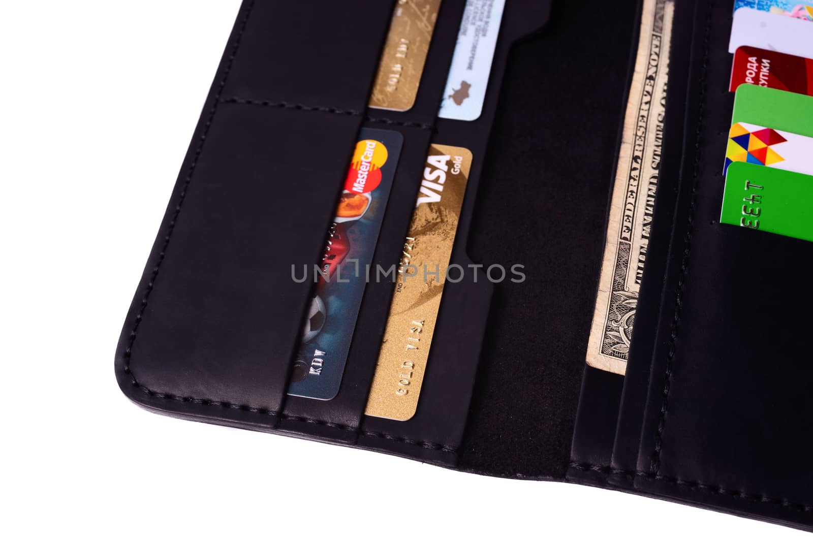 24.01.2019 Ukraine, Kyiv. A part of handmade black leather wallet isolated on white background closeup. A lot of plastic cards in purse pockets. Editorial use only.