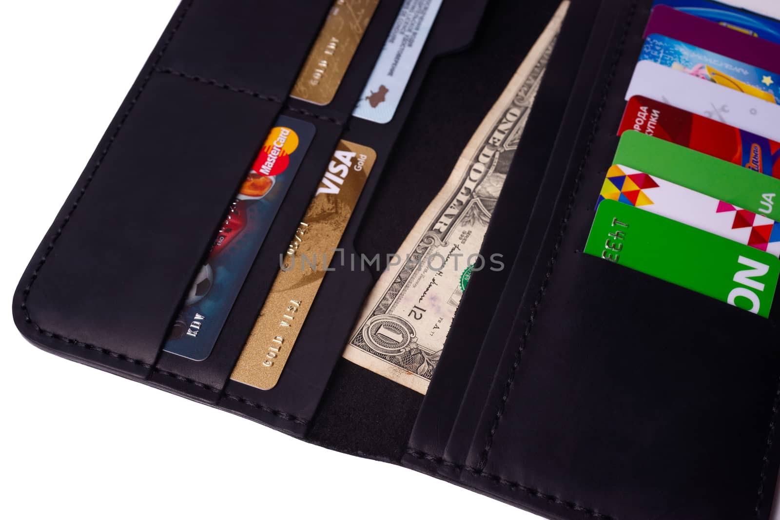 24.01.2019 Ukraine, Kyiv. A part of handmade black leather wallet isolated on white background closeup. A lot of plastic cards in purse pockets. Editorial use only.