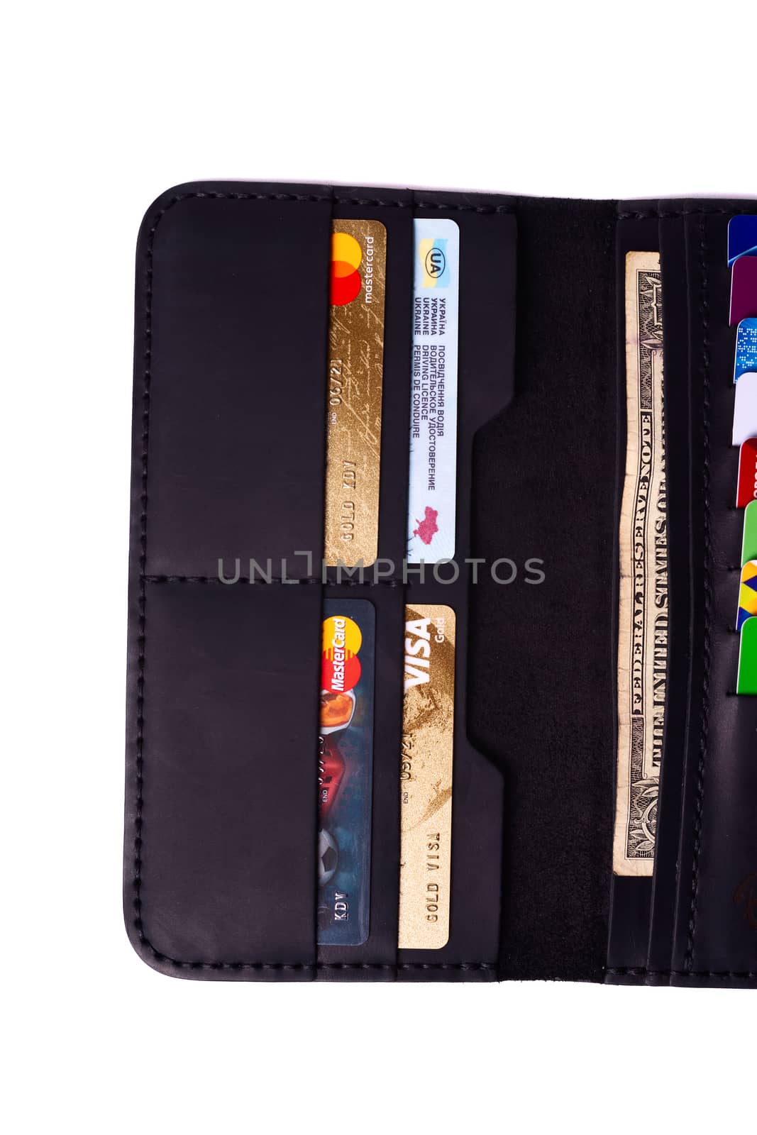 24.01.2019 Ukraine, Kyiv. A part of handmade black leather wallet isolated on white background closeup. A lot of plastic cards in purse pockets. Editorial use only.