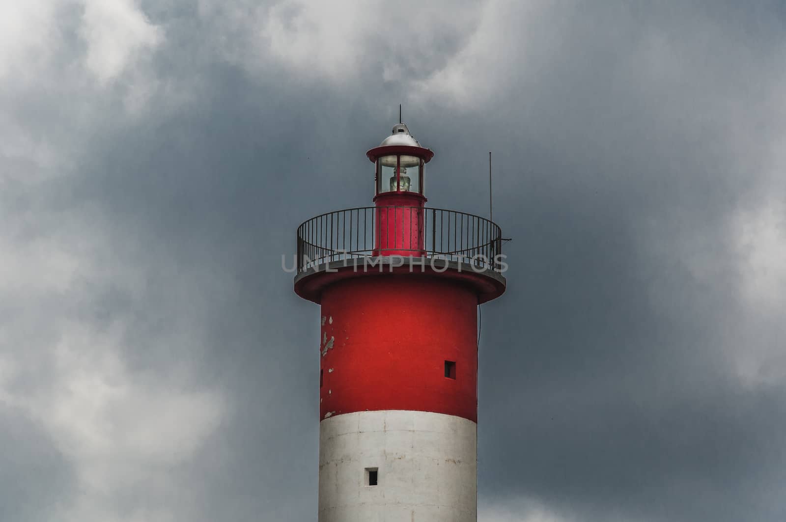 Lighthouse of Port-La-Nouvelle in red and white on cloudy sky in Occitanie, France