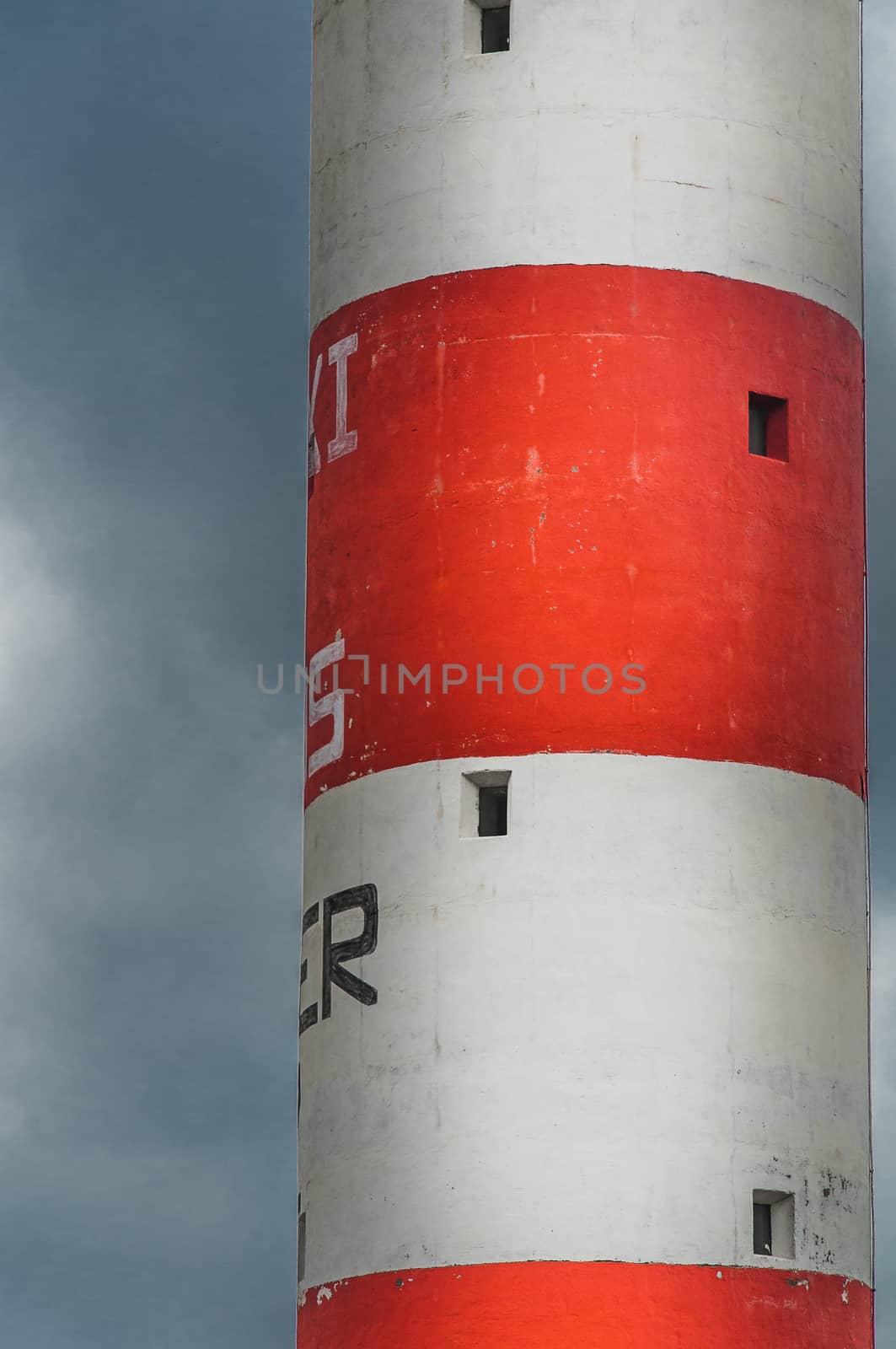 Lighthouse of Port-La-Nouvelle in red and white on cloudy sky in Occitanie, France