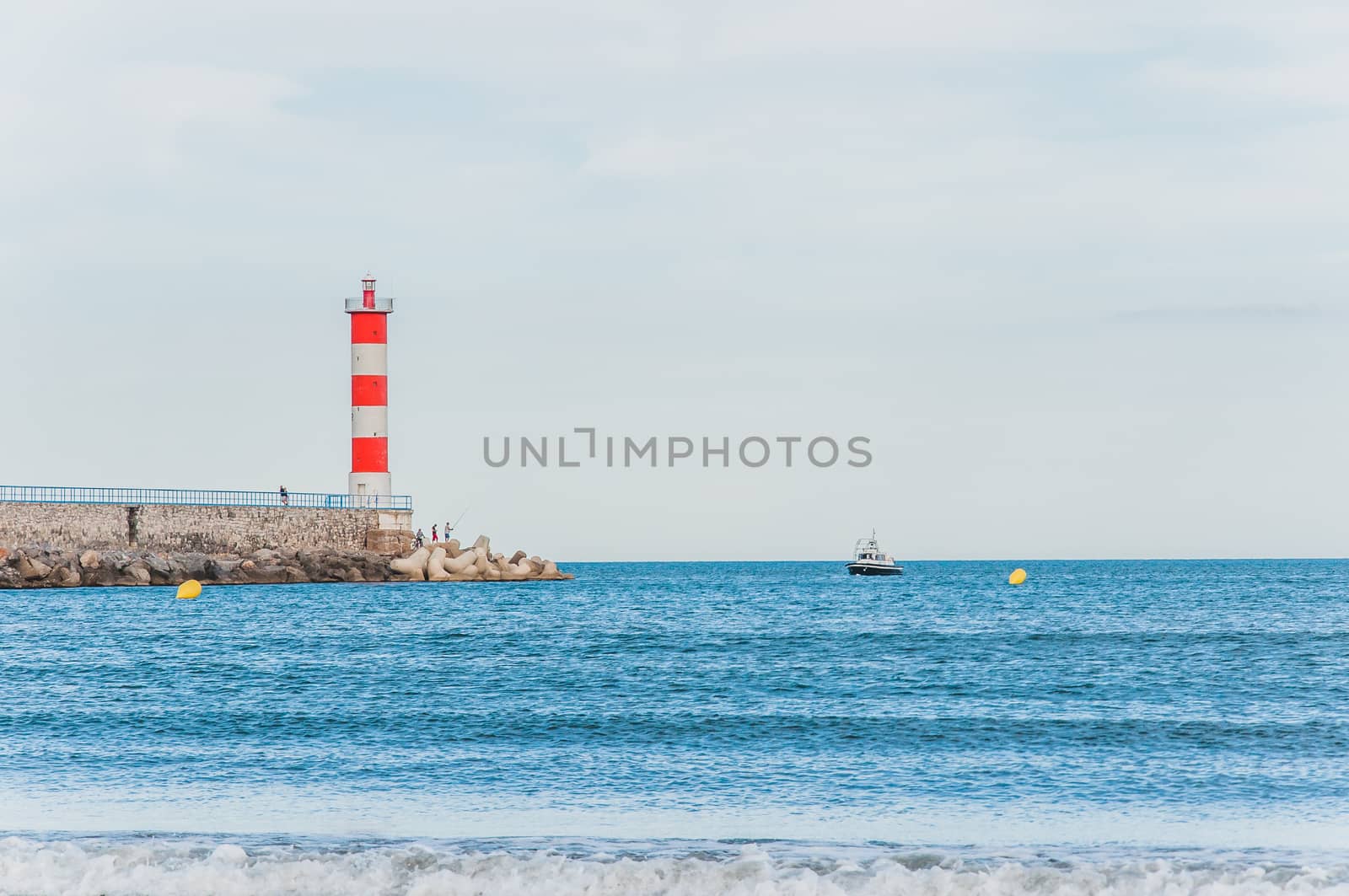 Lighthouse of Port-La-Nouvelle in red and white on cloudy sky in Occitanie, France
