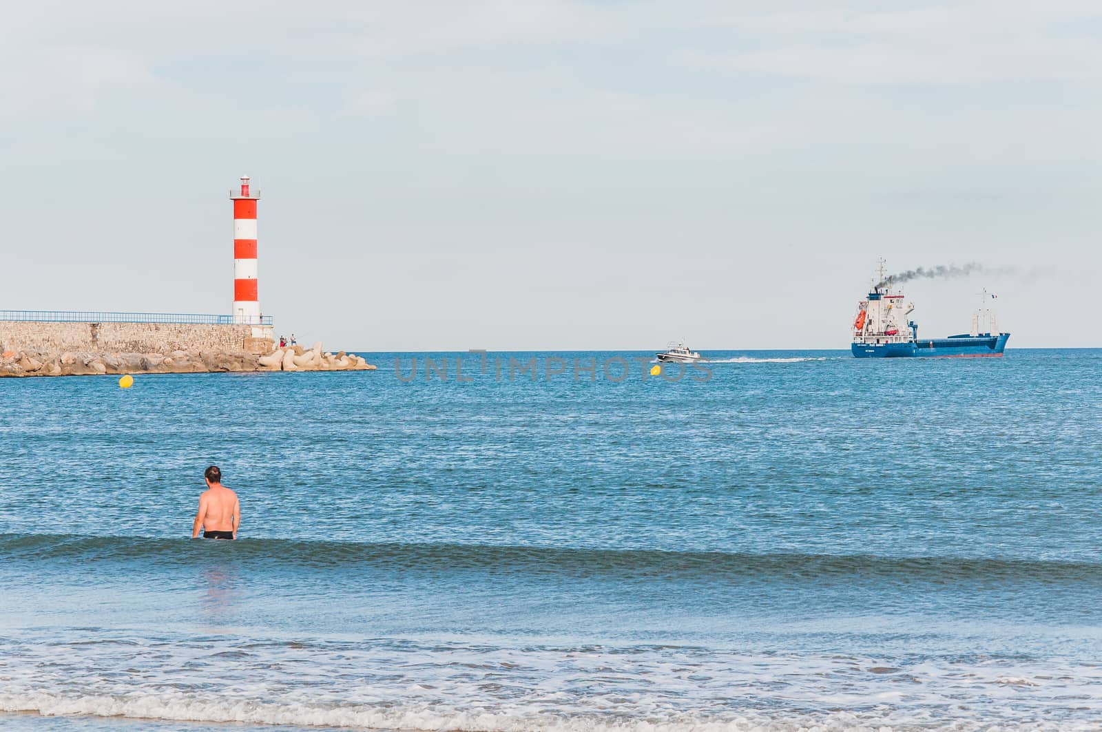 Lighthouse of Port-La-Nouvelle in red and white on cloudy sky in Occitanie, France