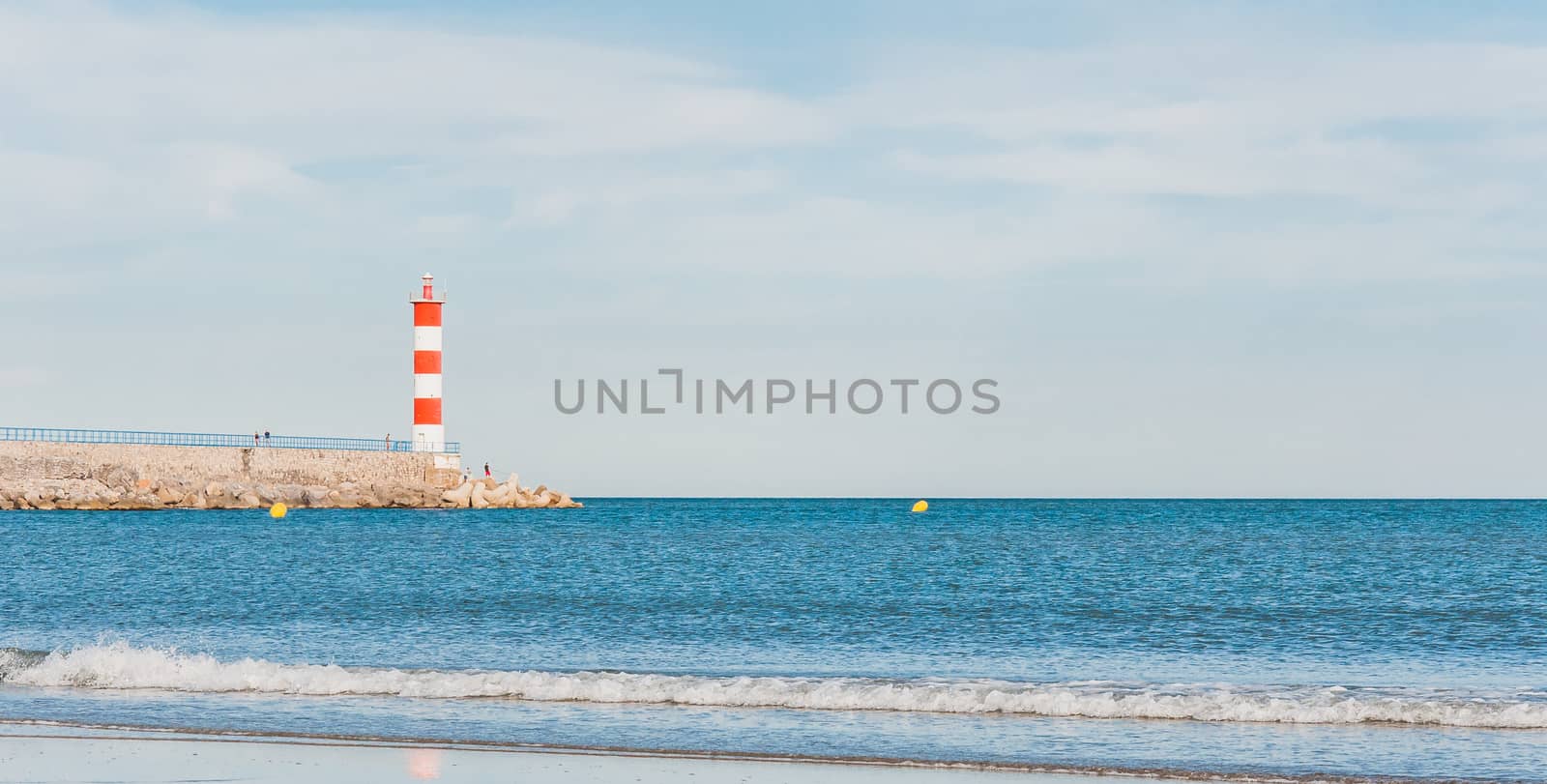 Lighthouse of Port-La-Nouvelle in red and white on cloudy sky in Occitanie, France
