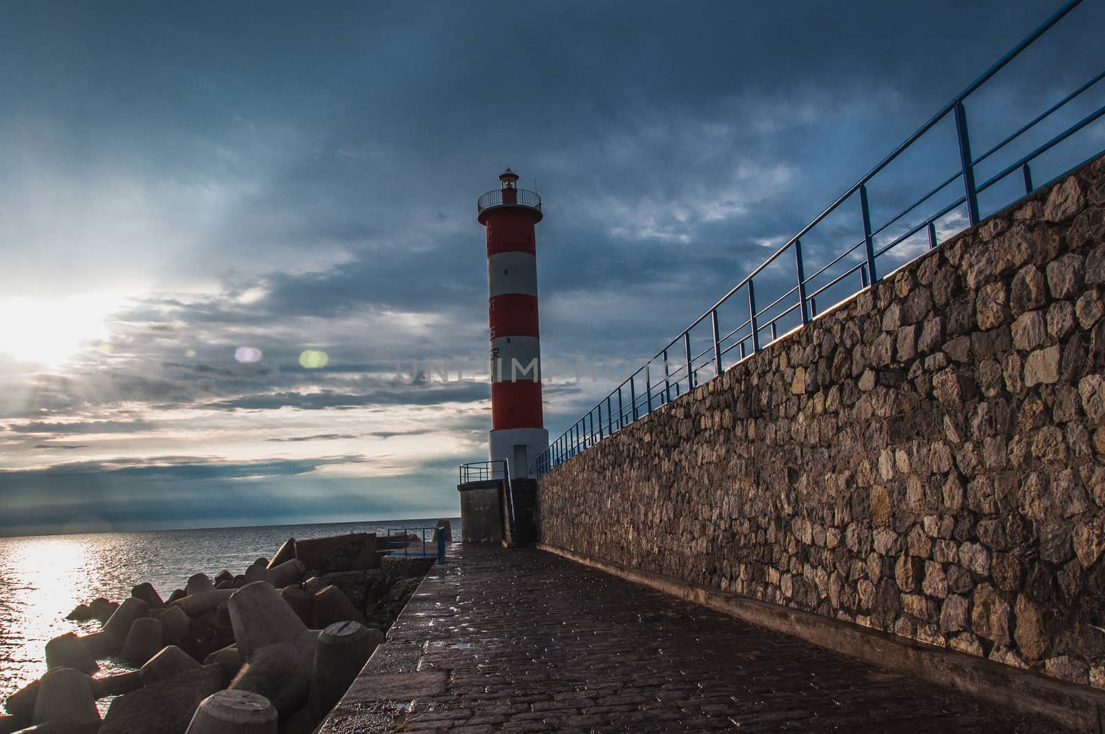 Lighthouse of Port-La-Nouvelle in red and white on cloudy sky in Occitanie, France