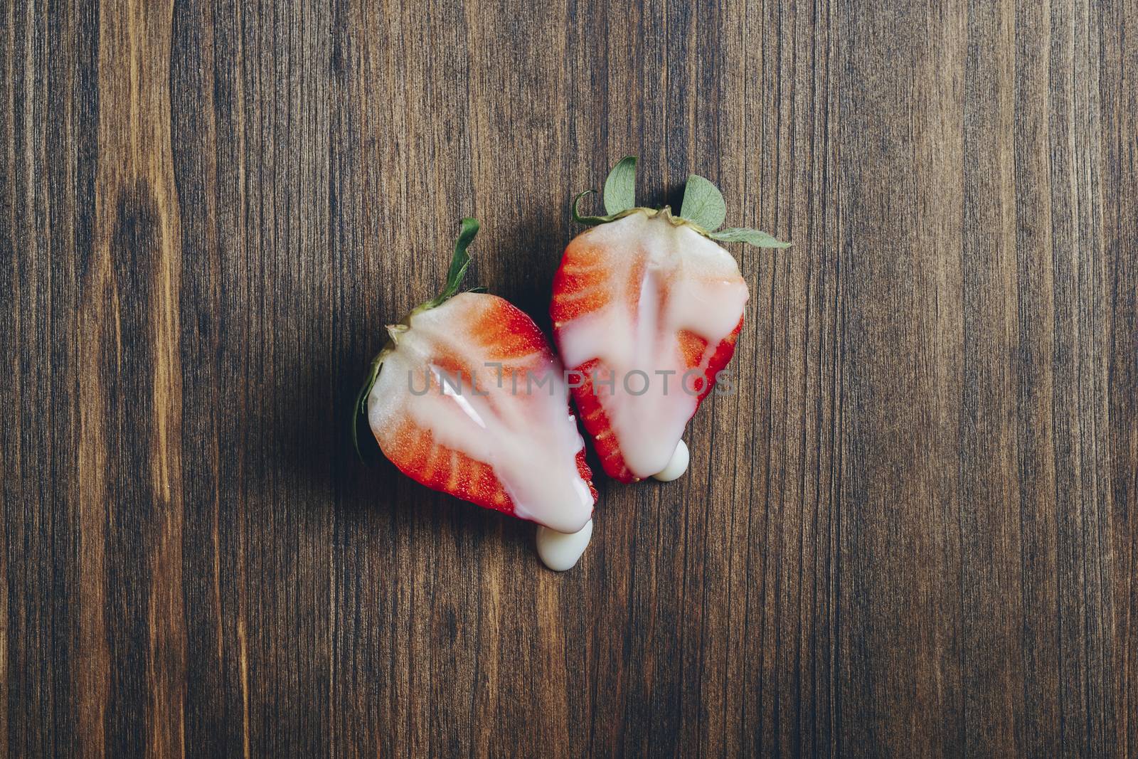 metaphor of sex with strawberries and milk on wooden background, top view, copy space for text