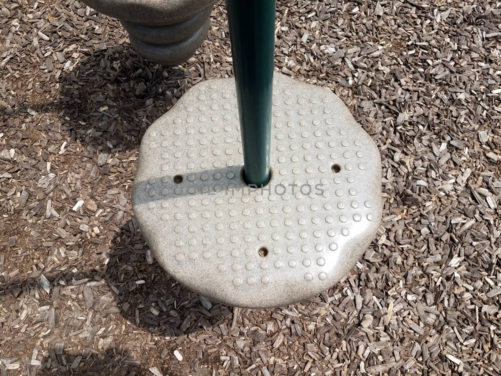 circular plastic platform with metal pole at playground play structure