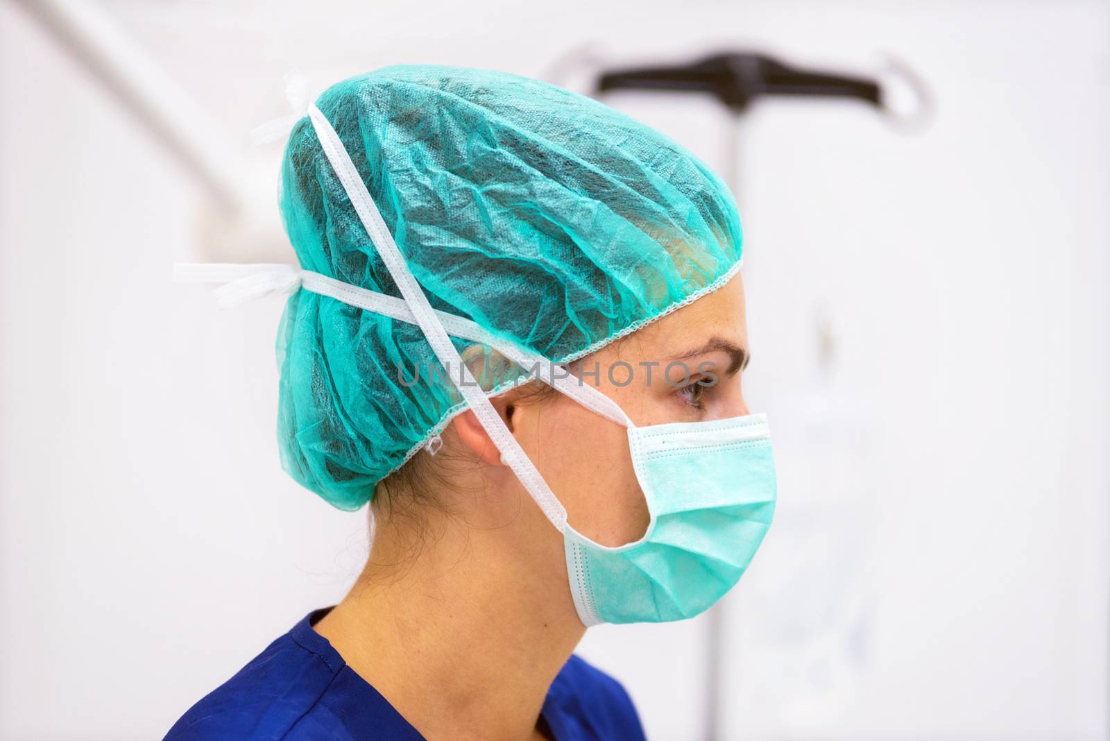 Doctor portrait with protective mask and hat in operating room by HERRAEZ