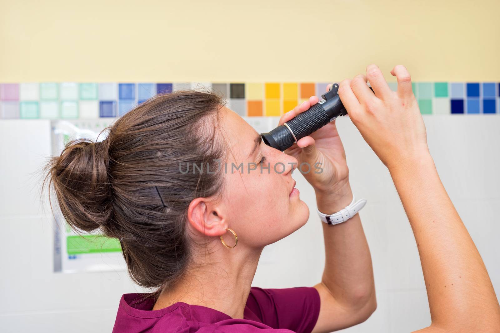 Doctor using refractometer for scientific test by HERRAEZ