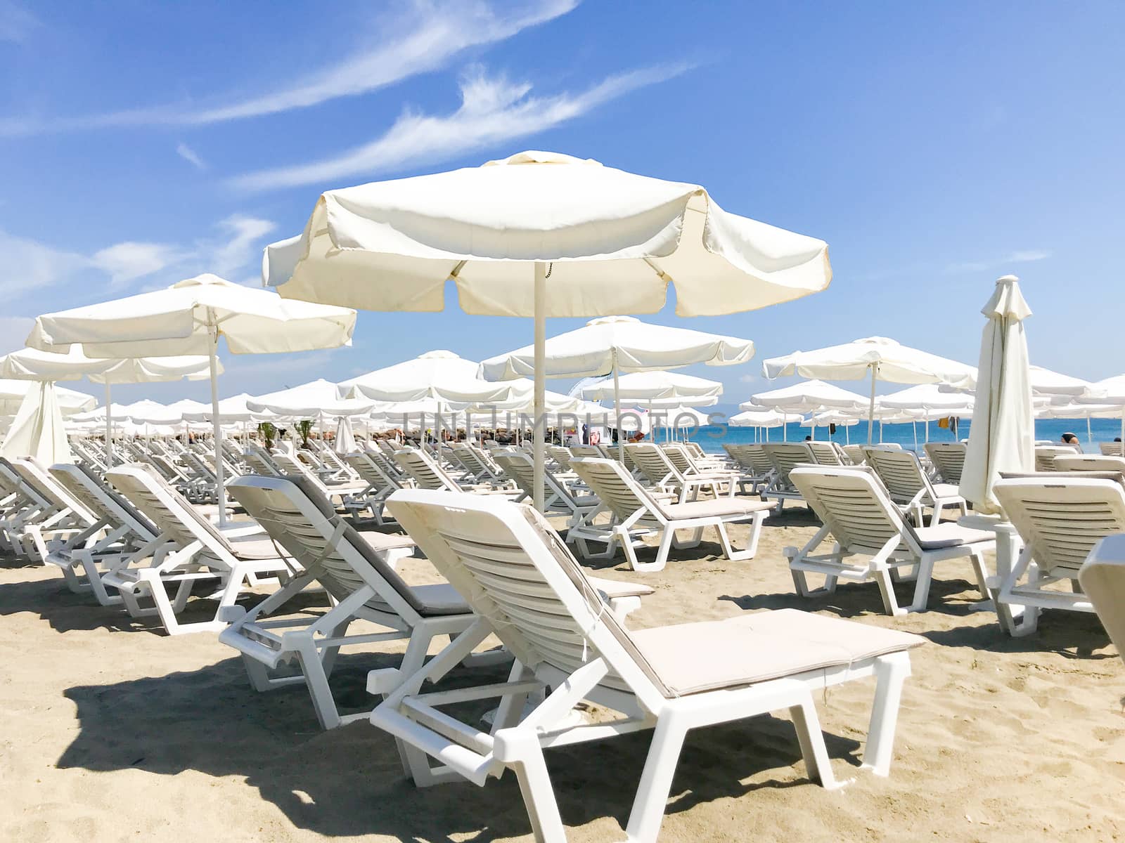 White Loungers And Umbrellas At The Beach In Pomorie, Bulgaria.