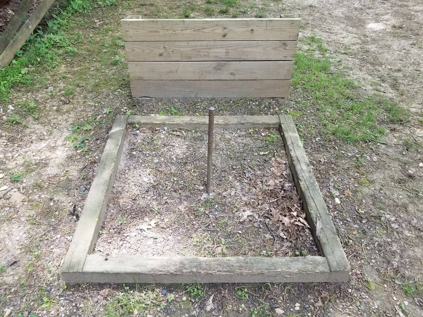 horseshoe pit with metal pole and wood backstop by stockphotofan1