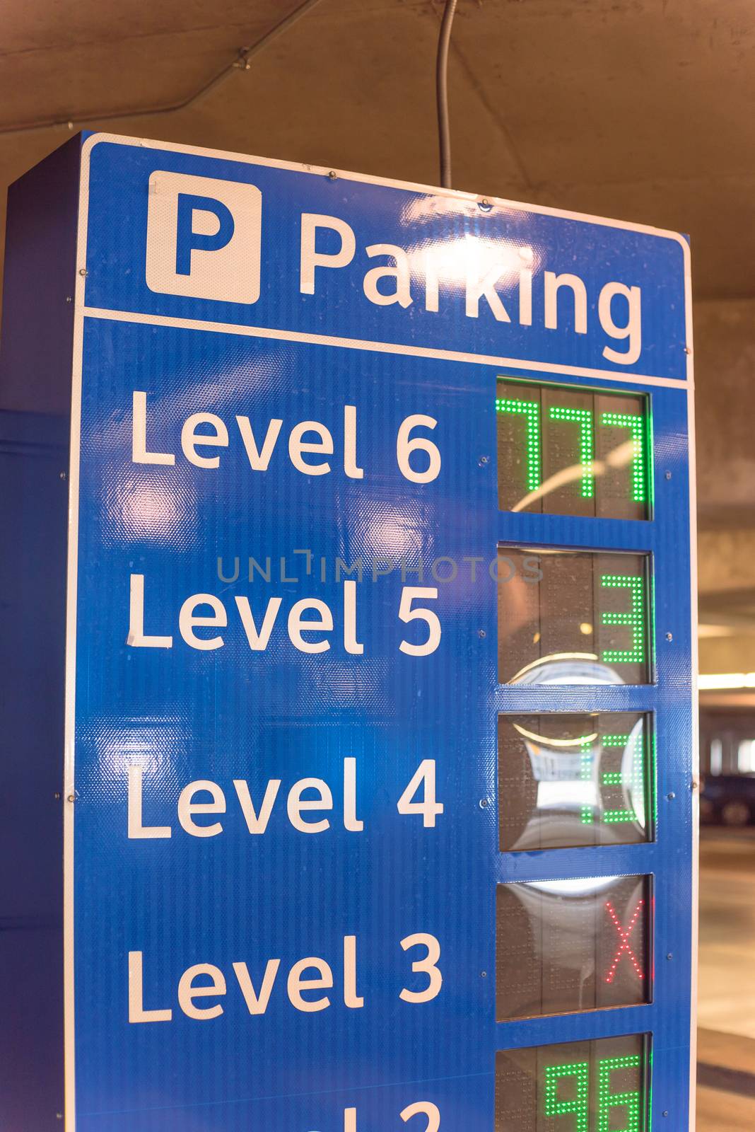 Multi-level garage smart guidance system with LED lighted numbers showing available or full spaces on each level. Intelligent indoor parking garage management
