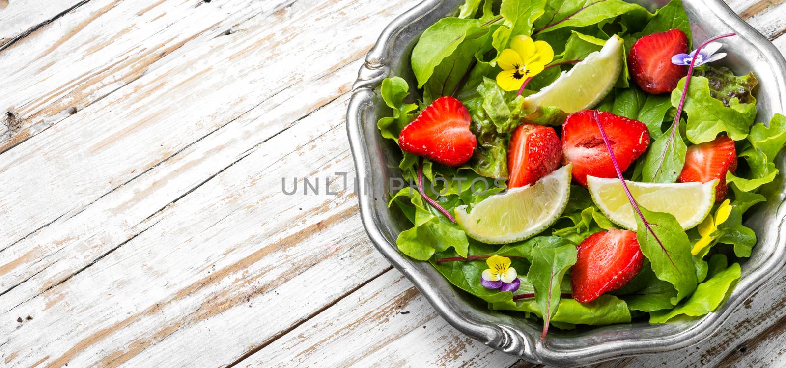 Light salad with greens, strawberries and lime.Summer food