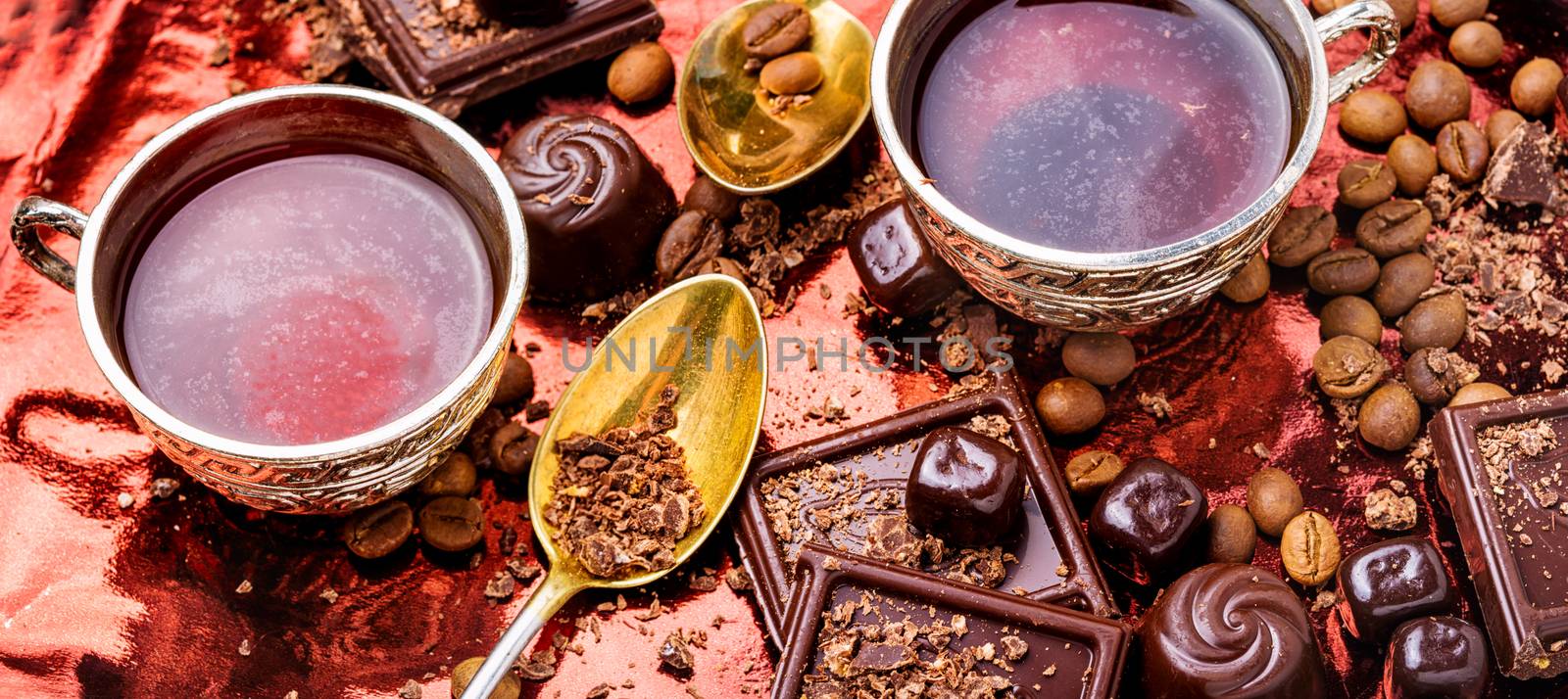 Hot coffee and sweets.Coffee cup, beans,chocolate on kitchen table