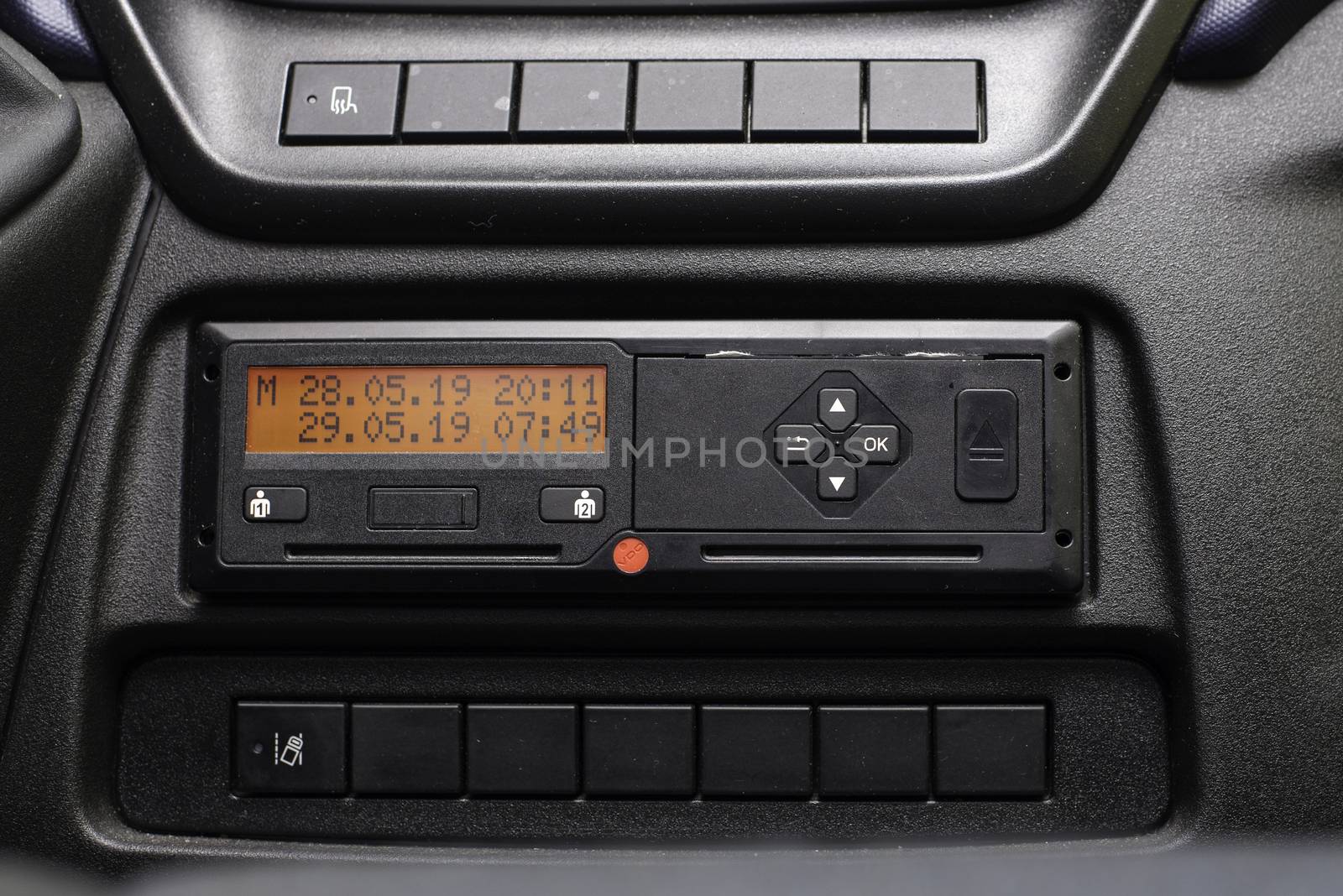 Digital tachograph display shows time difference after driver inserts the card into the device when starting shift. No personal data. Tachograph in a van.