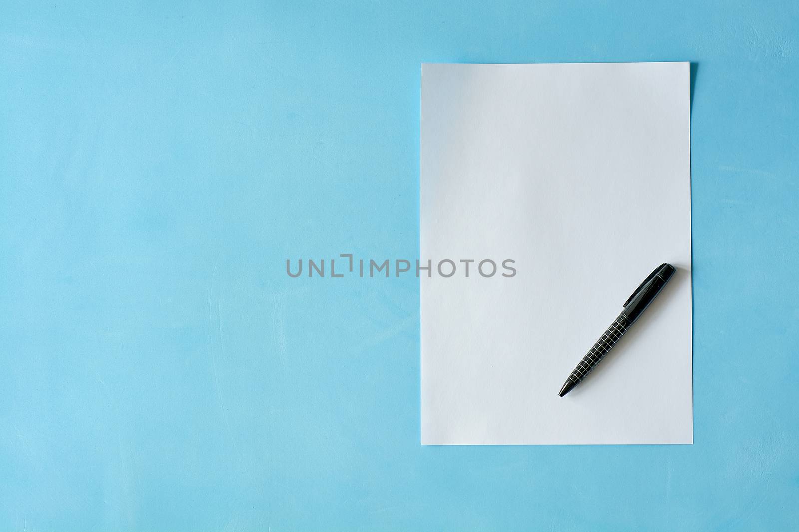 White sheet paper with black pen on blue background with copy space for text. Print disign consept.