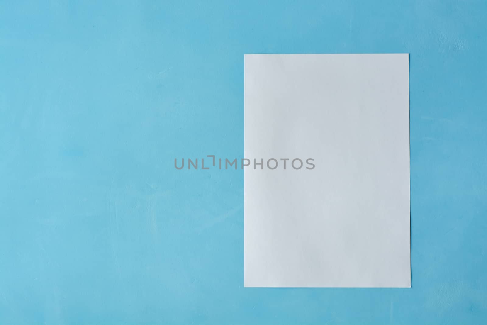 White sheet paper on blue background with copy space for text. Print disign consept.