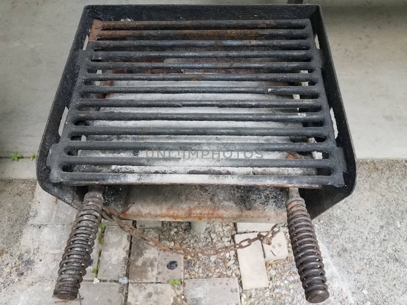 dirty or filthy barbecue grill metal bars with charcoal ash