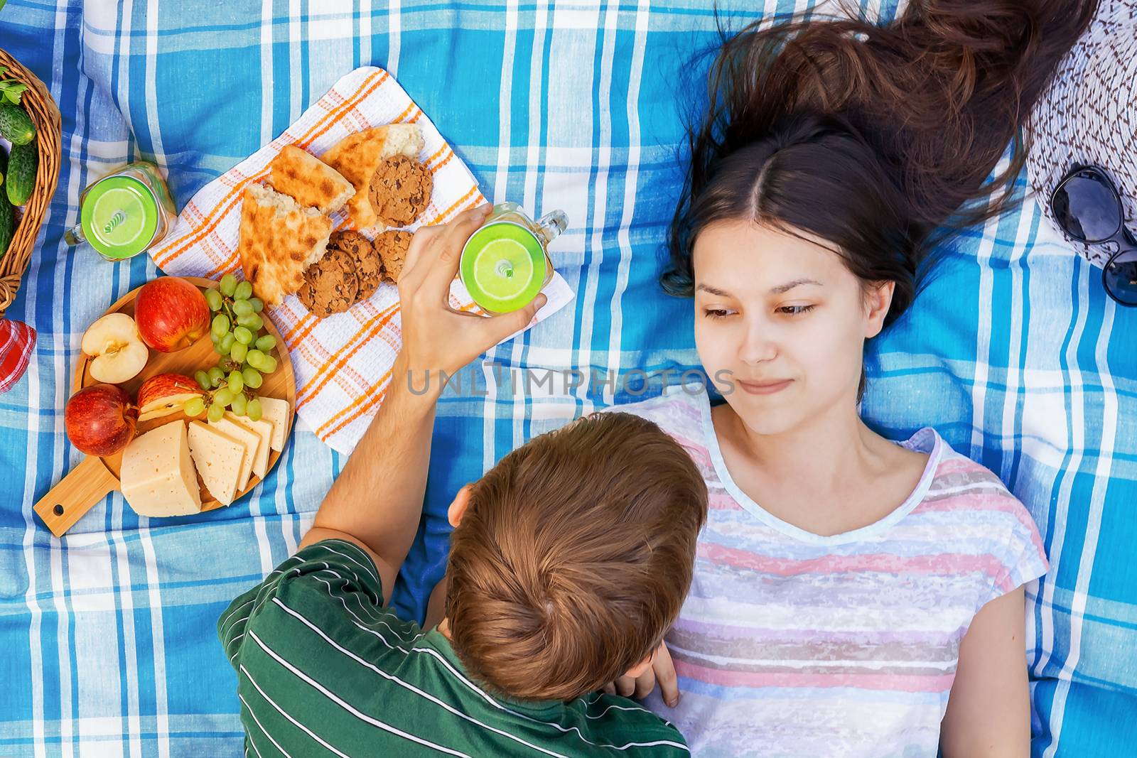 Young loving couple resting on a picnic on a summer day.