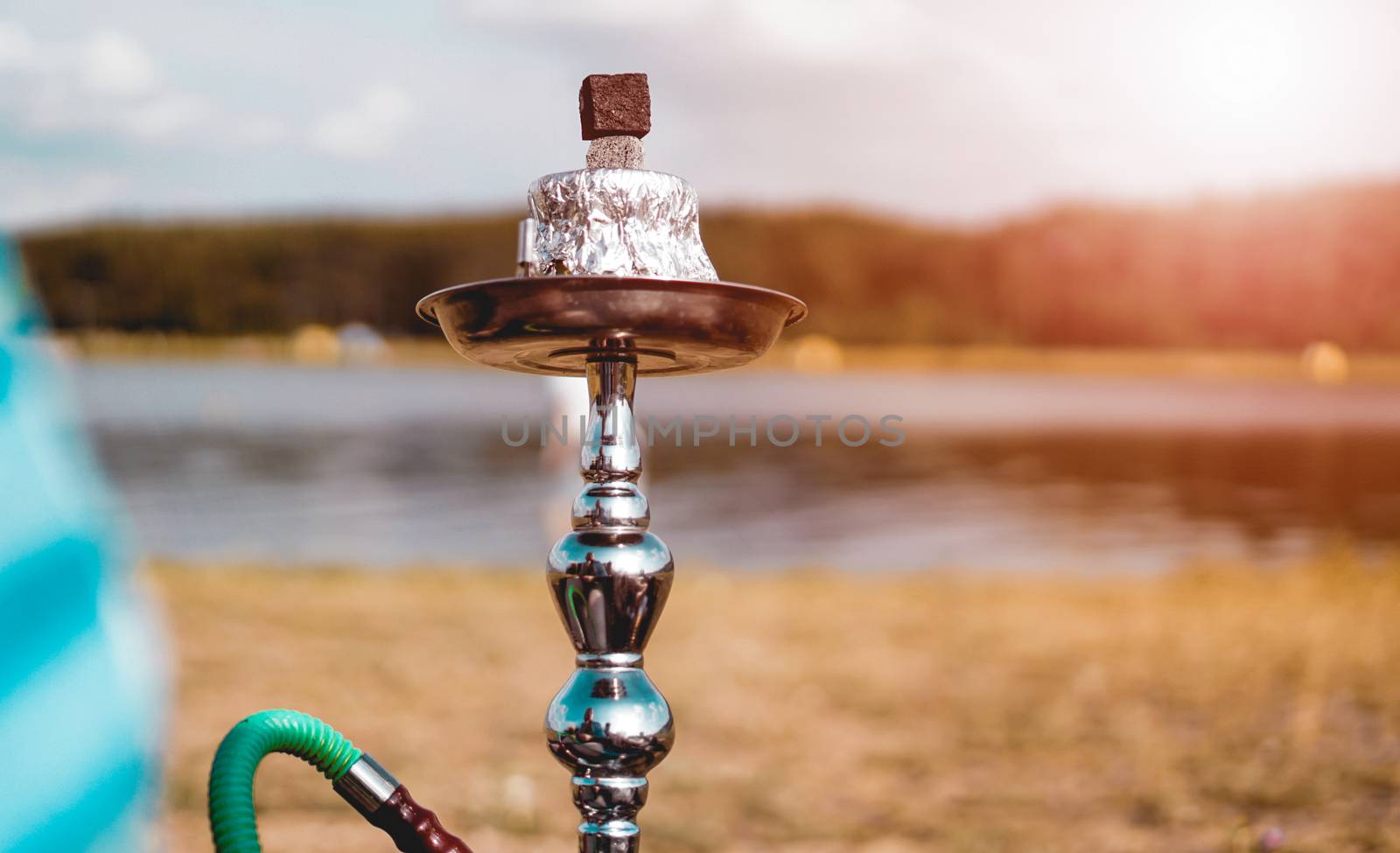 Summer vacation, activity. environment, travel and hookah smoking concept. Hookah bowl stands in nature by the river close up