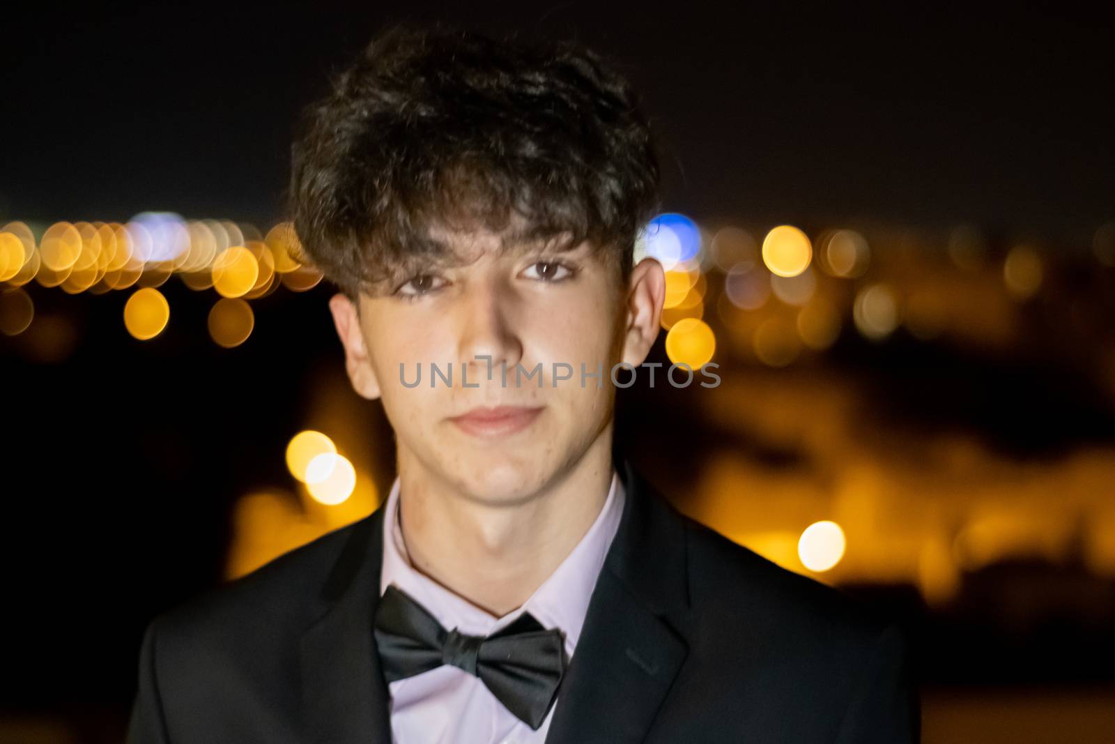 Night portrait of young boy in suit