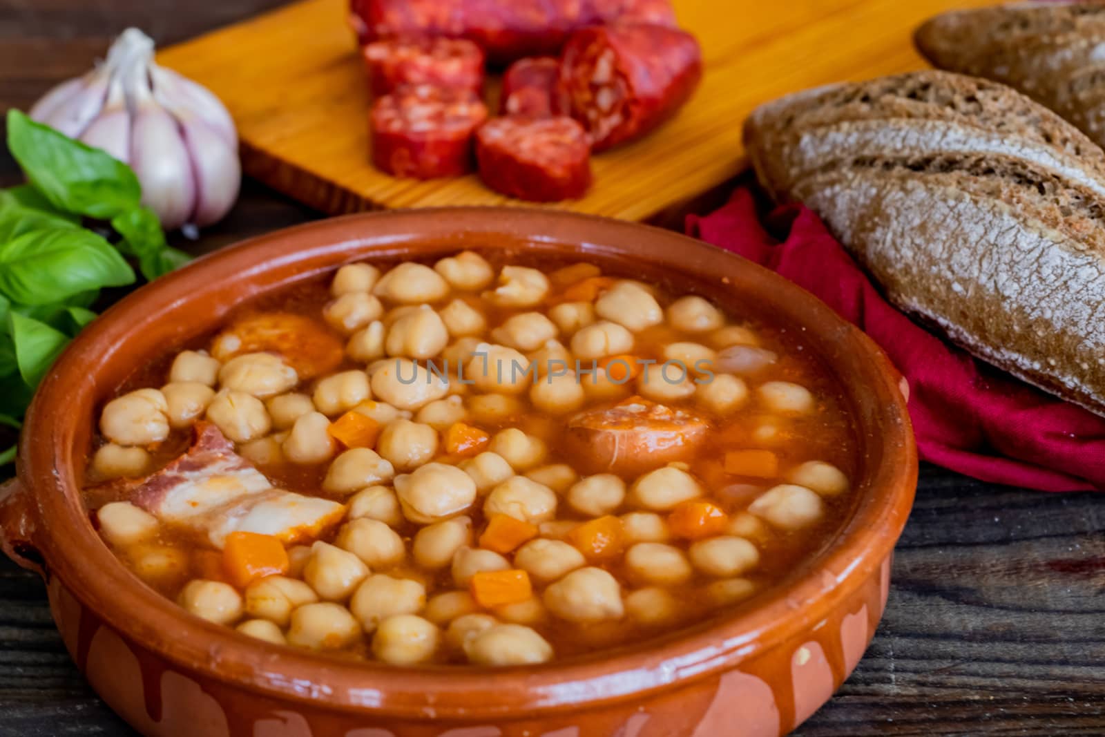 Chickpea dish and ingredients in composition on wooden background