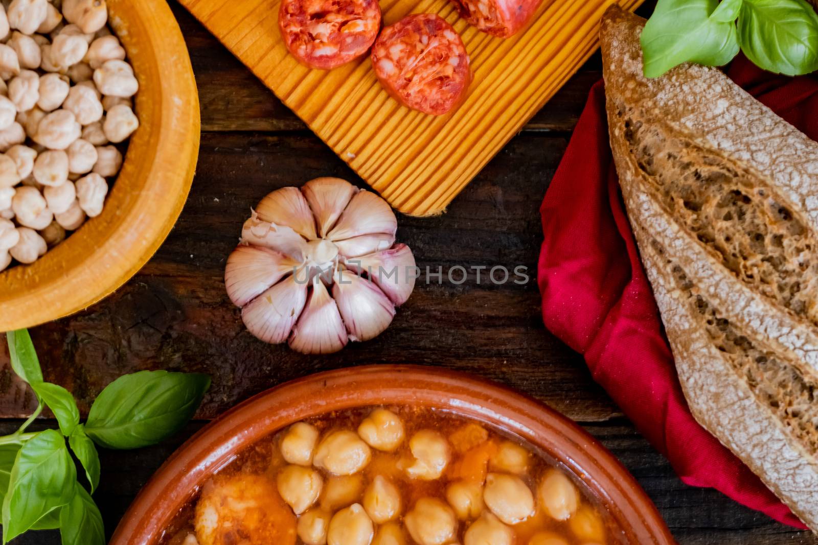 Chickpea dish and ingredients in composition on wooden background