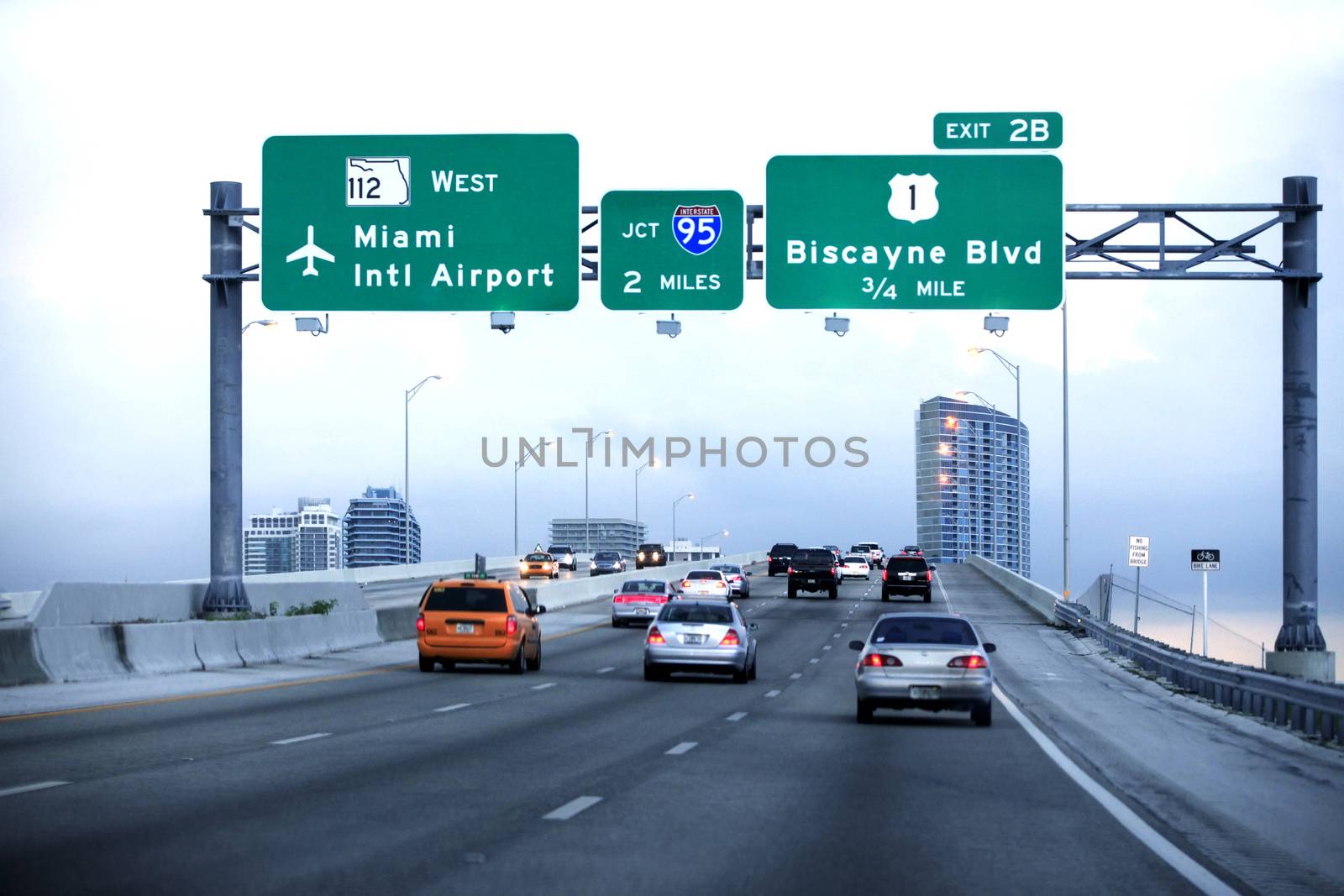 Cars moving on a highway with directional signs to Miami Interna by friday