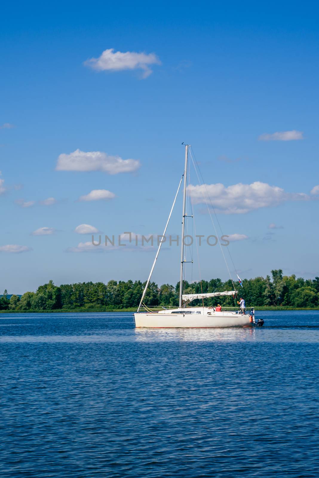 White Sailing Boat on the River at Cloudy Day.