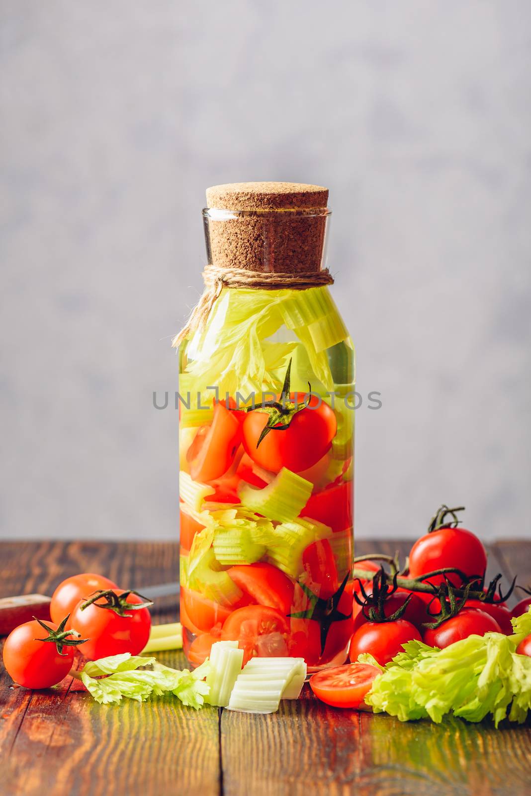 Summer Beverage: Detox Water with Sliced Clery Stems and Cherry Tomato. Vertical Orientation.
