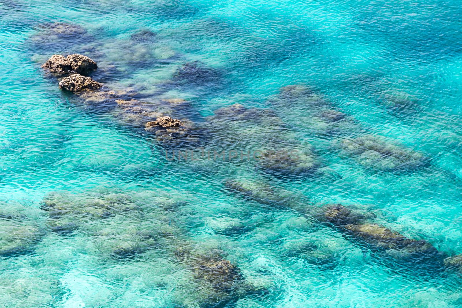 Top view of transparent shallow turquoise ocean sea water surface and rock at andaman sea indian ocean in summer.