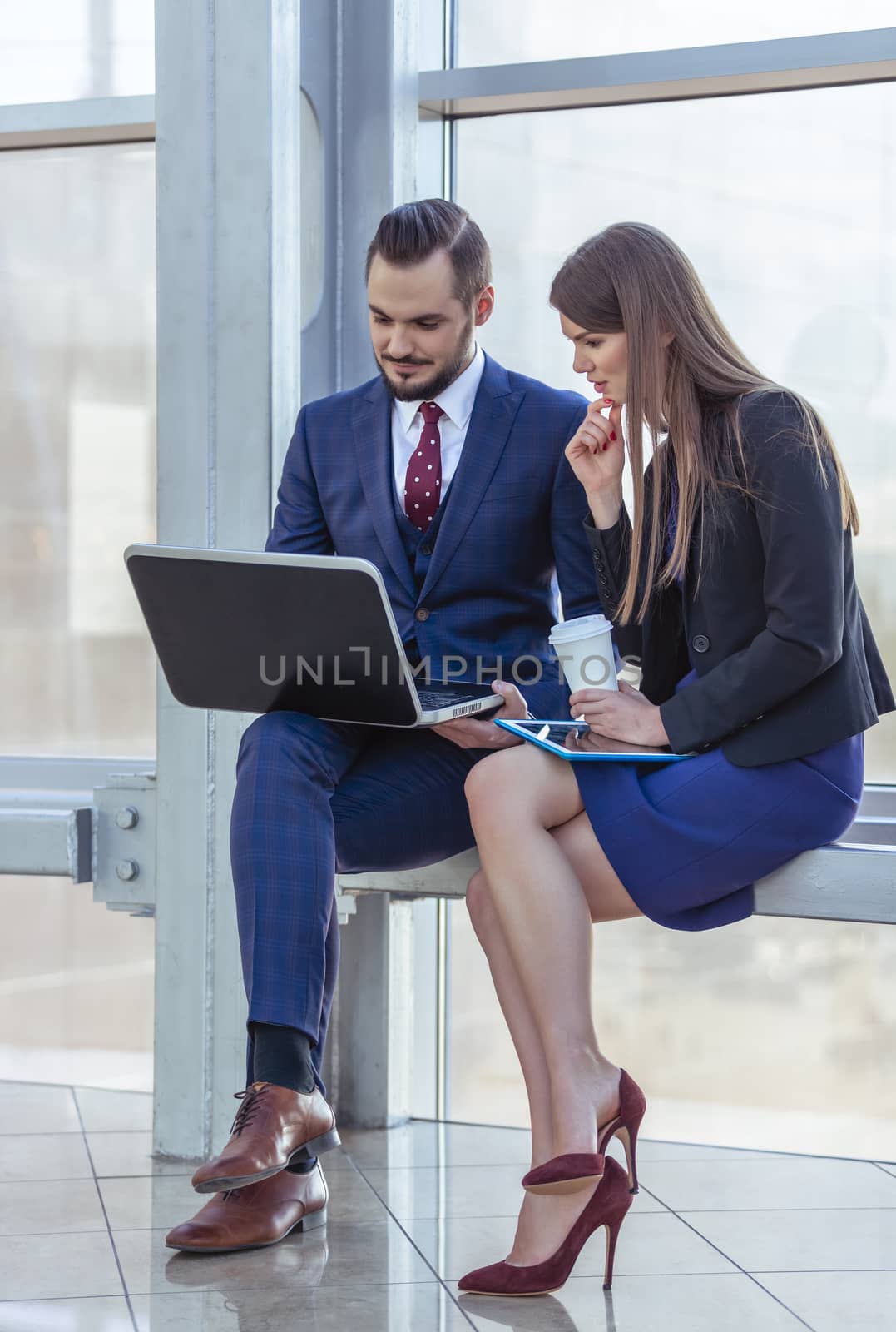 Business people having a break, sitting with laptop and smiling