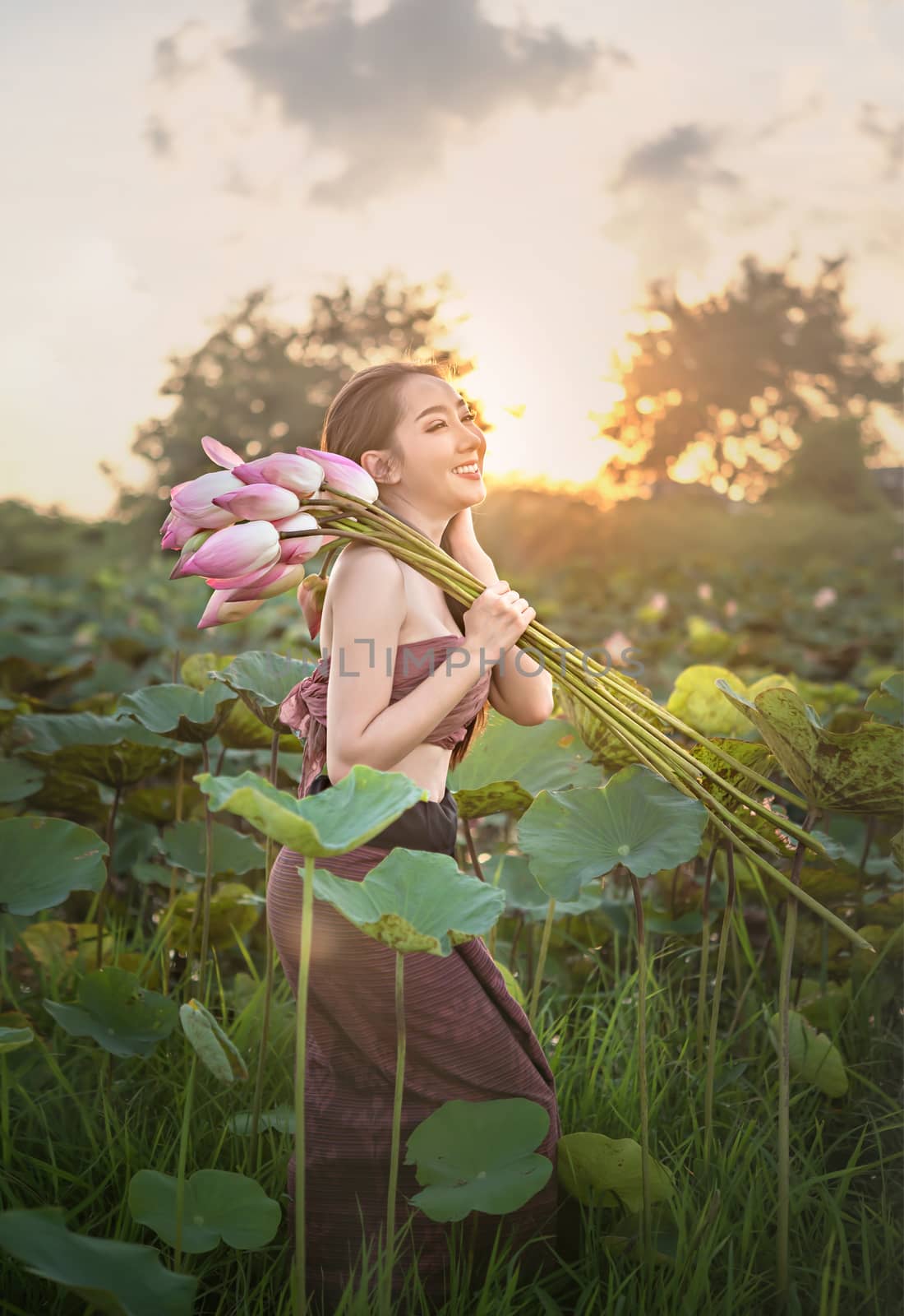 woman harvesting water lilies by rakratchada