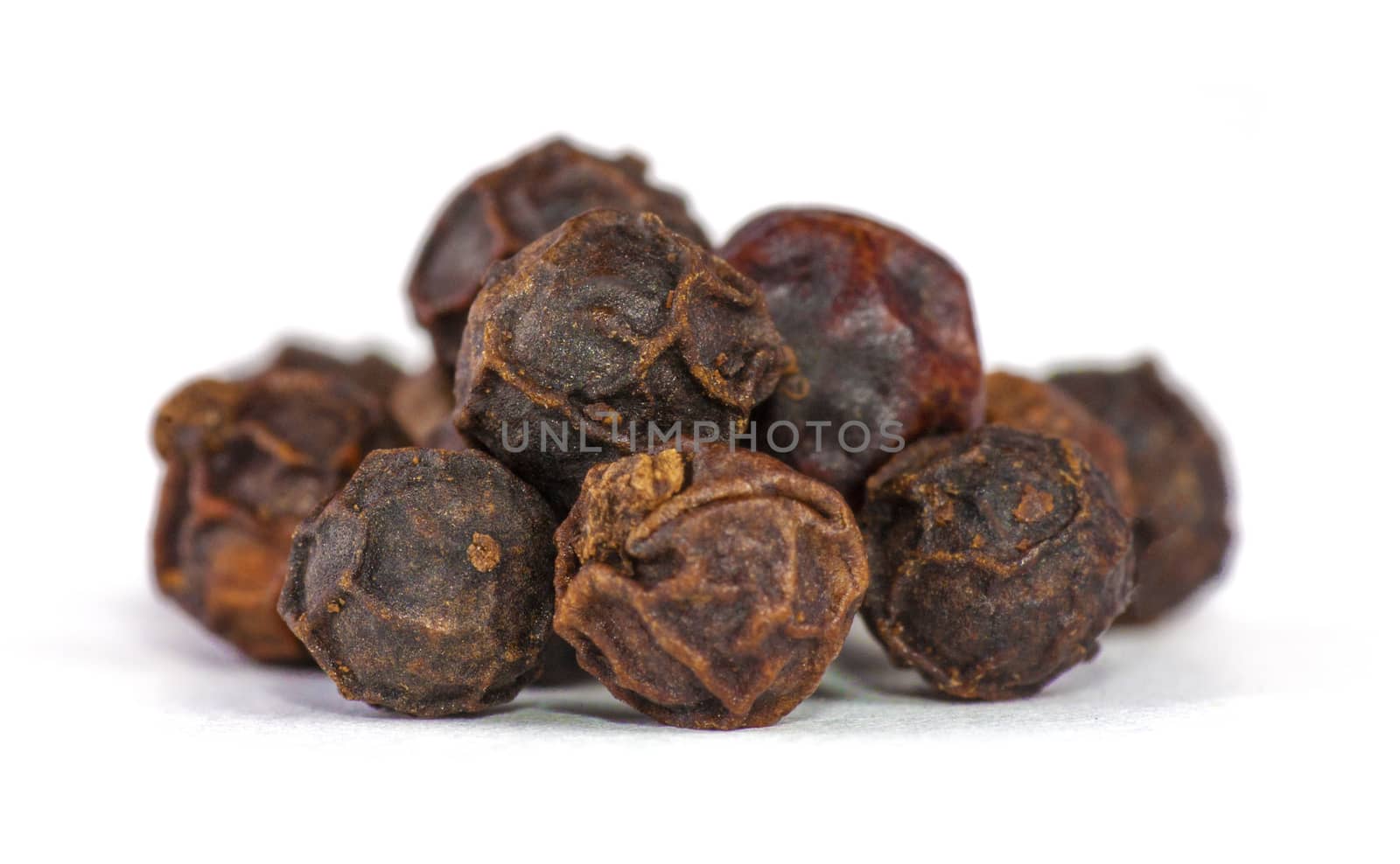 Dryed berries of Black Pepper on white background. Soft focus. Closeup view.
