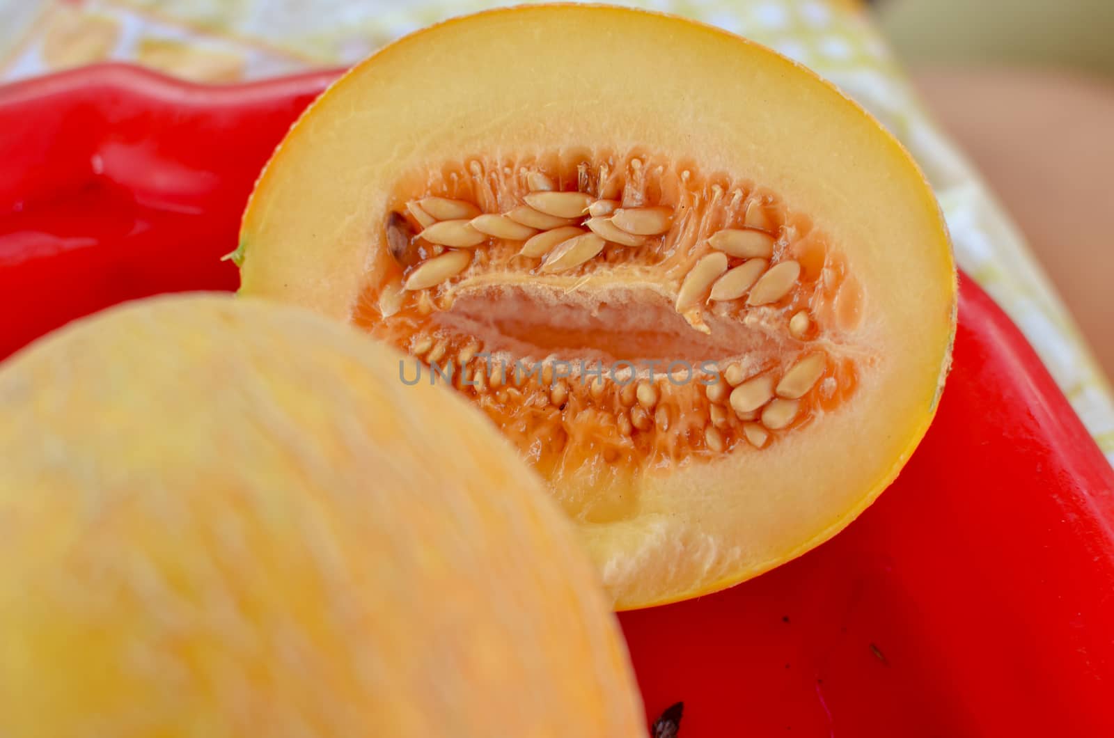 Cut ripe melons on red tray on the table close-up