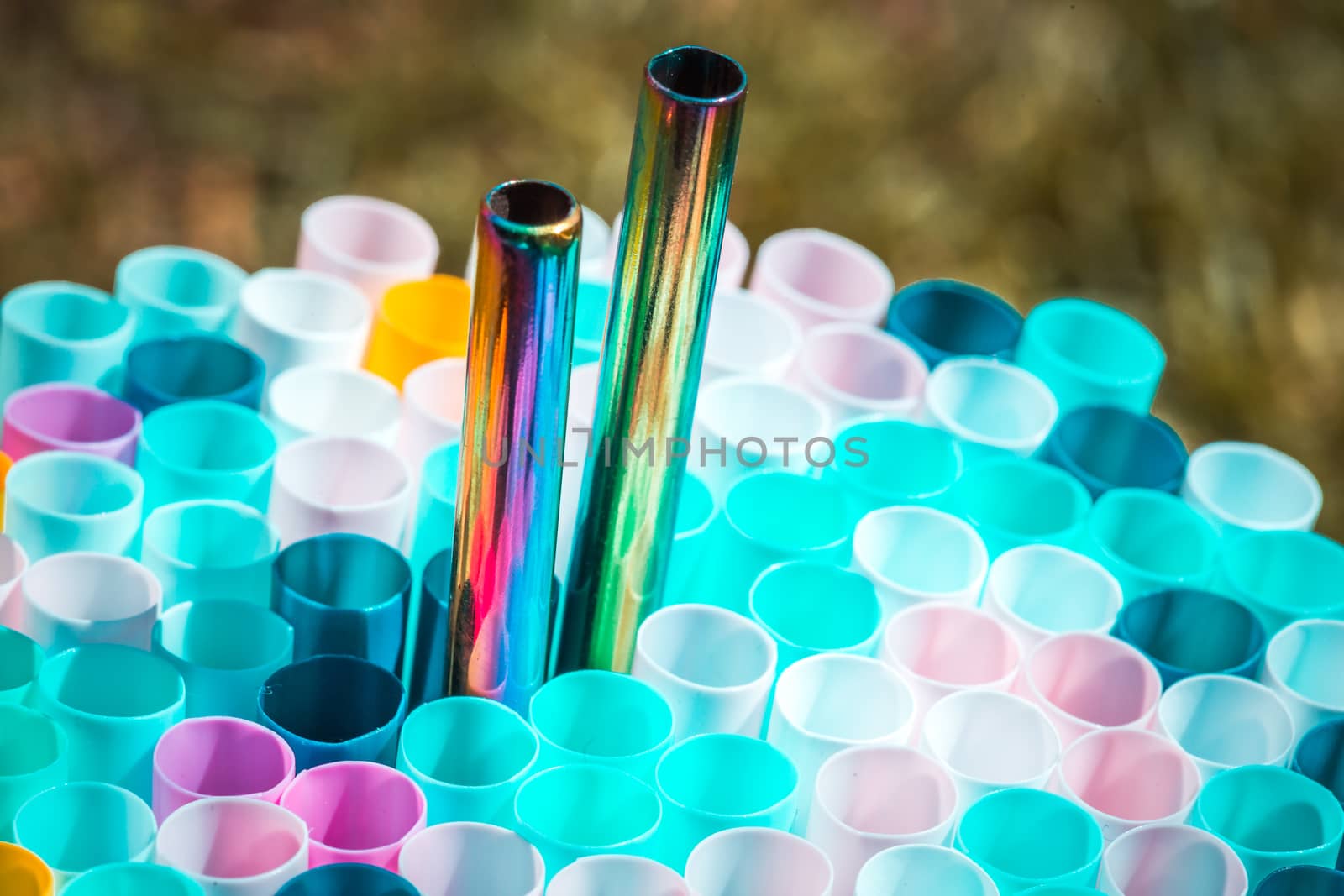 plastic and metal straw on colorful background.