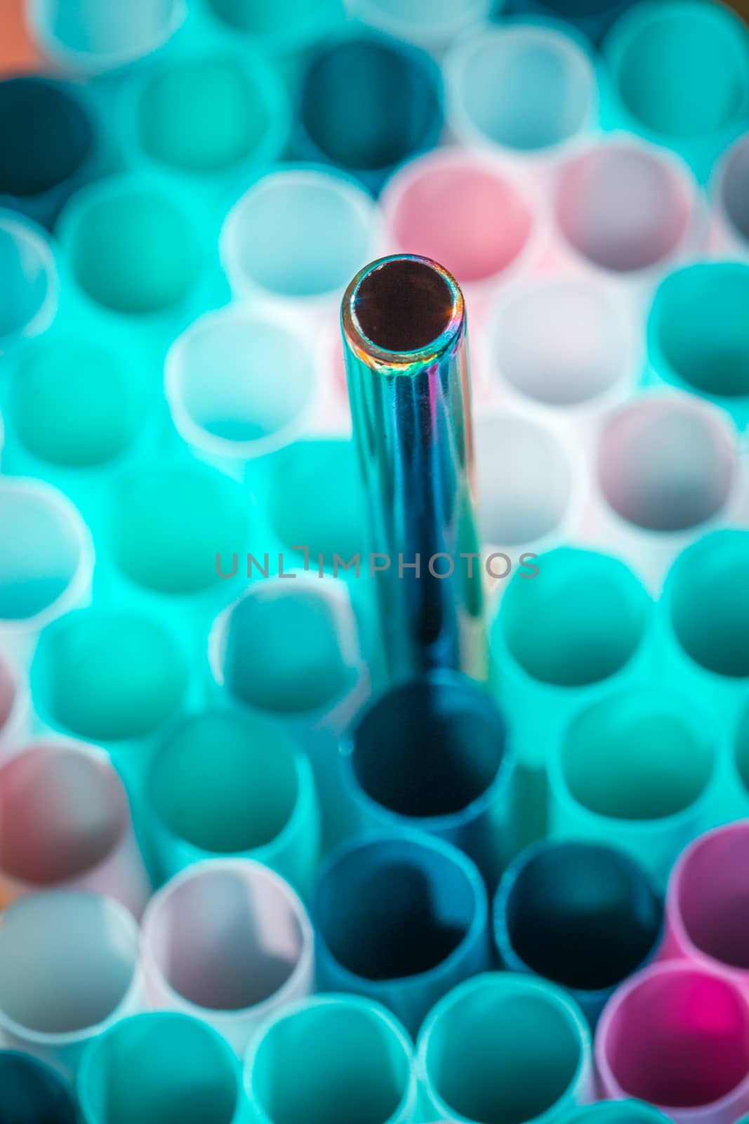 plastic and metal straw on colorful background.