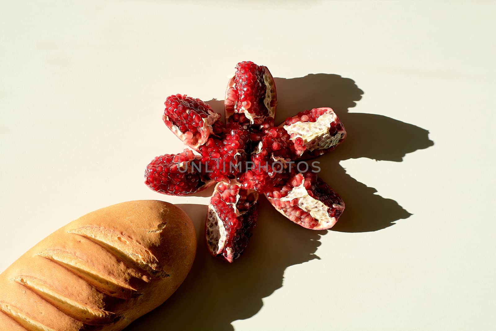 Bread long loaf and ripe red juicy pomegranate. by nixrenas