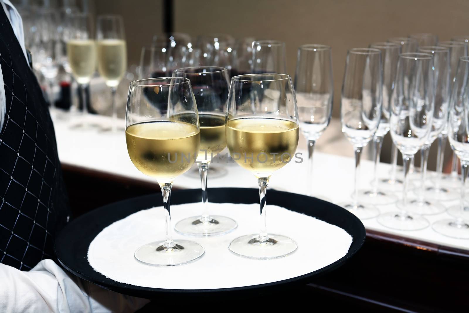 Cocktail party. Waiter holding platter with cold white wine