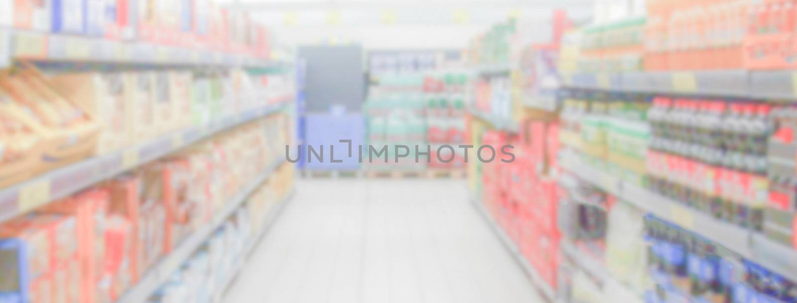 Defocused background within the aisles full of grocery goods in a supermarket or hypermarket convenience store. Intentionally blurred post production for bokeh effect