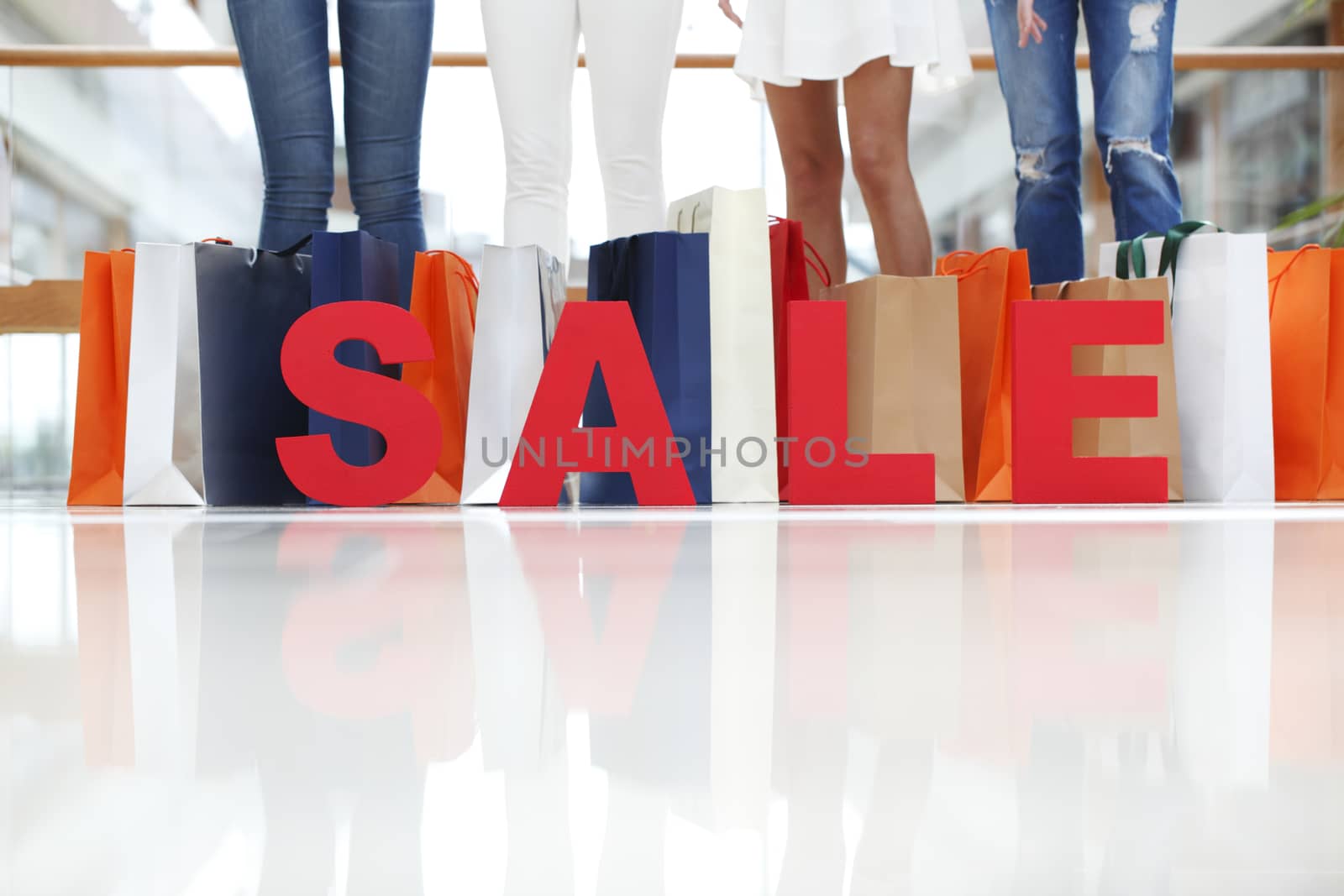 Girls with red sale letters in mall, shopping concept