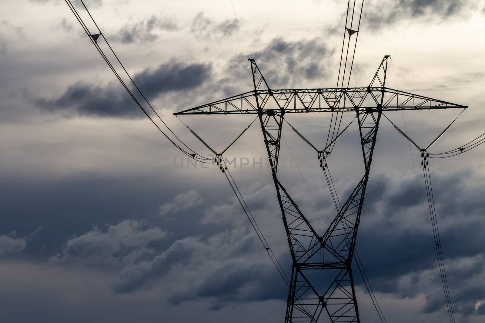 sky based shot of a power distribution tower with dark clouds in the background