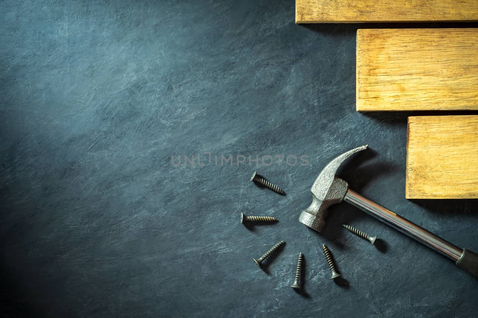 Hammer and lumber on black cement background. Top view and copy  by SaitanSainam