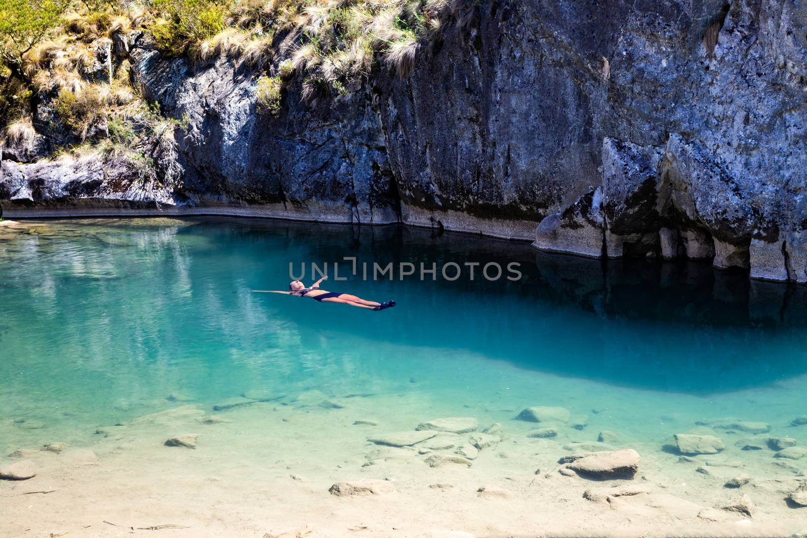 Female floating in natural blue pools by lovleah