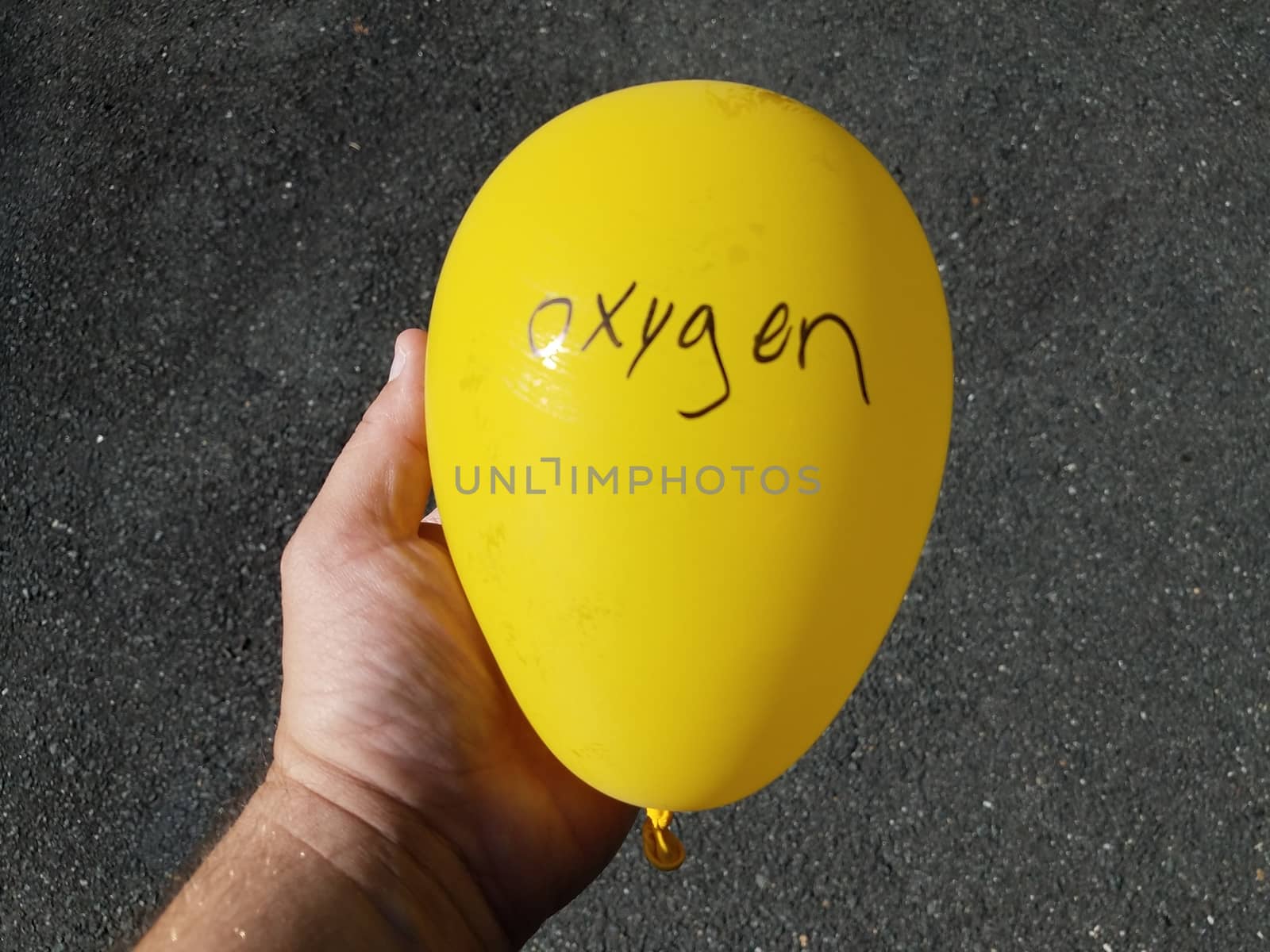 yellow balloon with oxygen written on it and hand holding it