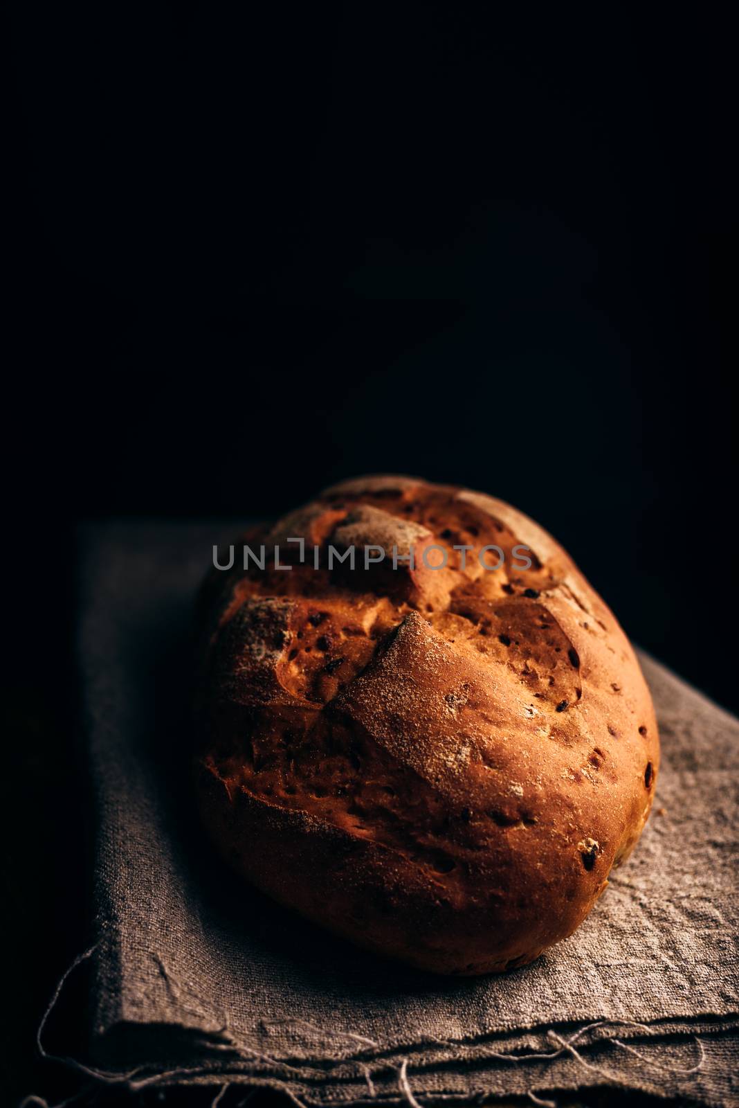 Loaf of Bread on Grey Cloth. Dark Background and Copy Space on the Top.