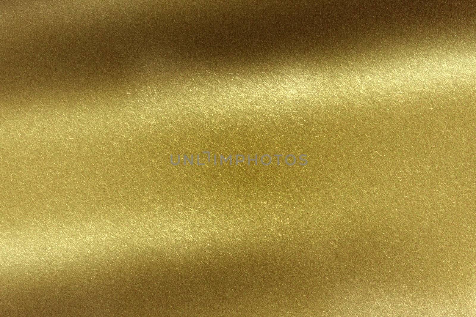 Light shining on brushed gold metal sheet, abstract texture background