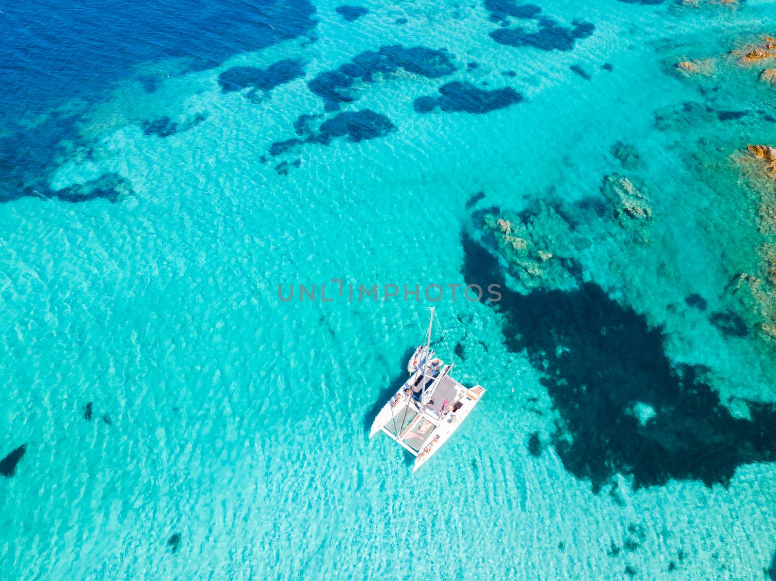 Drone aerial view of catamaran sailing boat in Maddalena Archipelago, Sardinia, Italy. by kasto