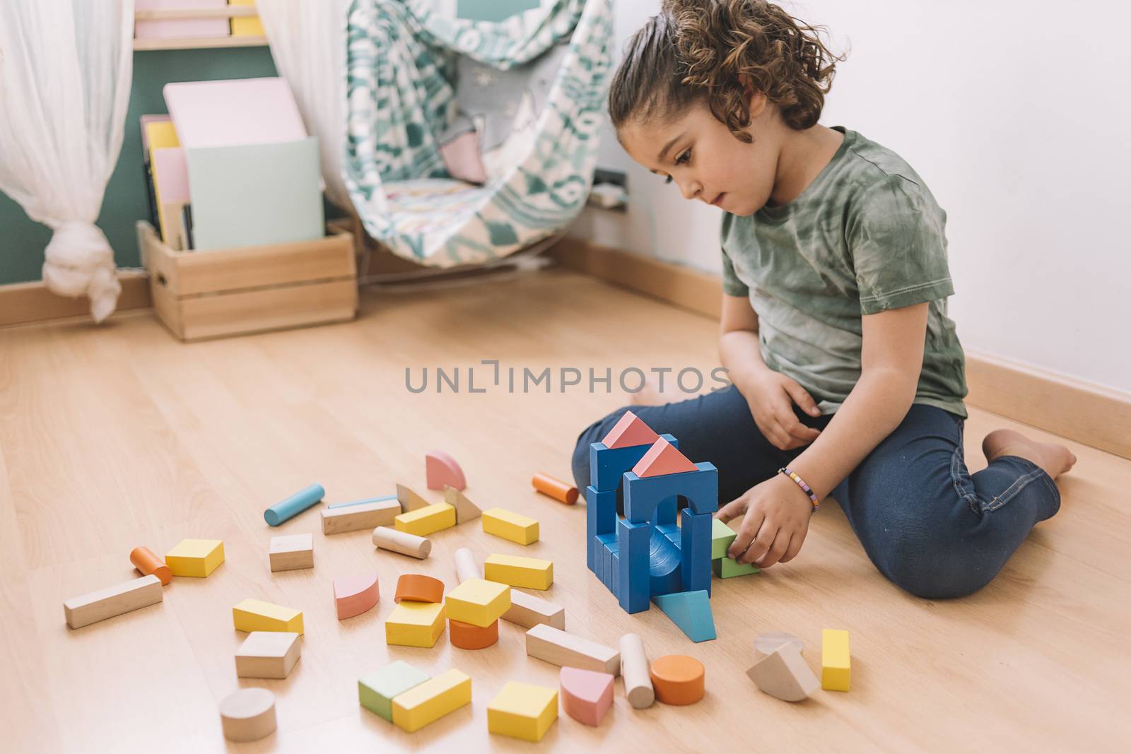 child little girl playing on the floor with wooden building block toys at home or kindergarten, educational toys for creative children