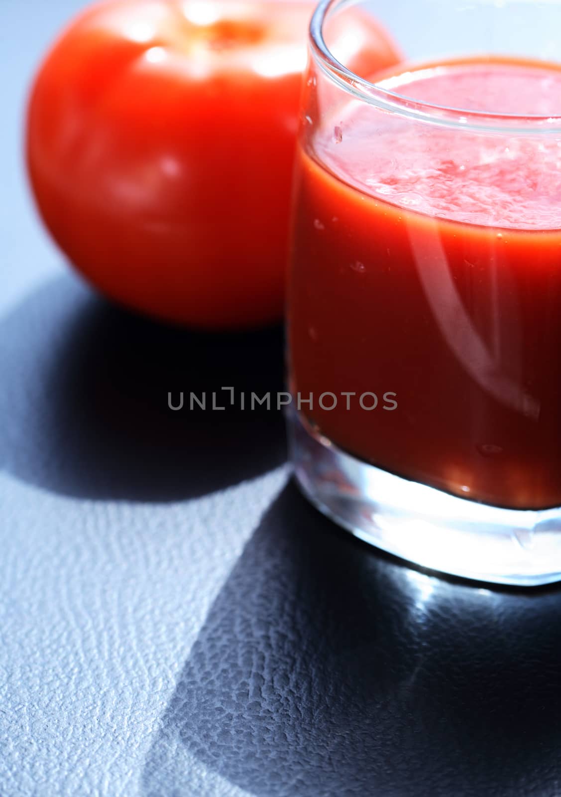 Full glass of tomato juice near freshness tomato